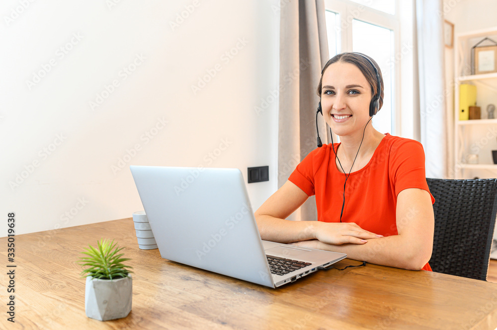 Woman works from home using headset and laptop Woman works from home using headset and laptop