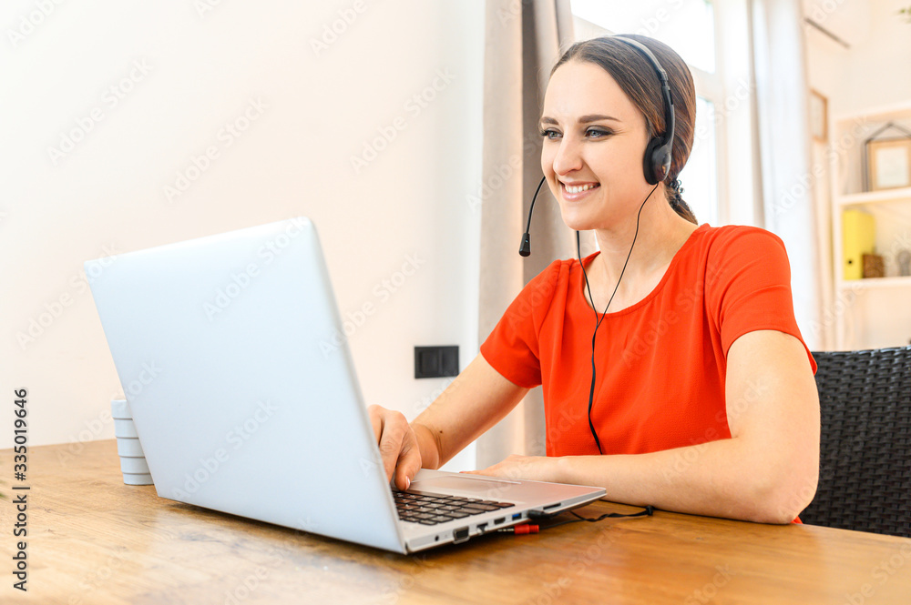 Woman works from home using headset and laptop Woman works from home using headset and laptop