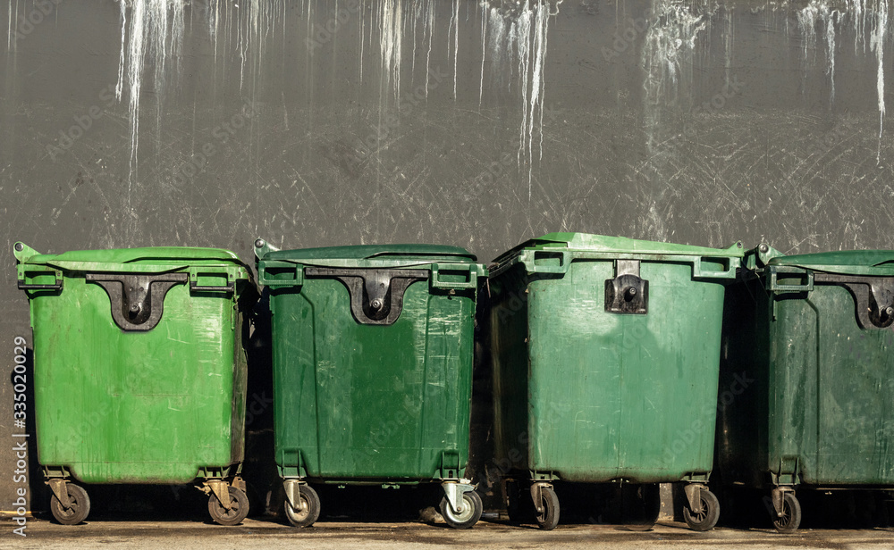 Large green plastic trash bins on wheels on asphalt for waste disposal of the Coronavirus epidemic Large green plastic trash bins on wheels on asphalt for waste disposal of the Coronavirus epidemic