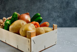 bio potatoes, carrots, zucchini, onions and ginger in a wooden box. Delivery fresh vegetables at home. food and grocery delivery. selective focus and copy space
