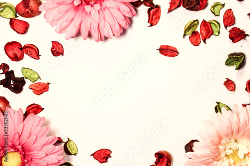 Frame of red flowers of chrysanthemum and dry red and green petals of roses. Top view. Flat lay. (ID: 335021413)