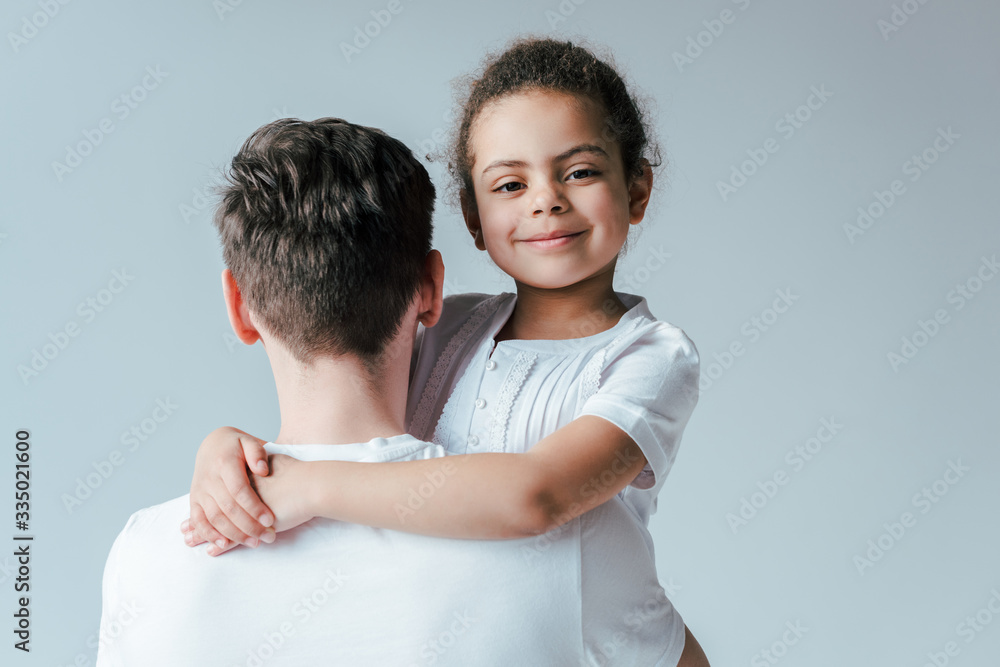 back view of foster father hugging happy adopted african american daughter isolated on white back view of foster father hugging happy adopted african american daughter isolated on white