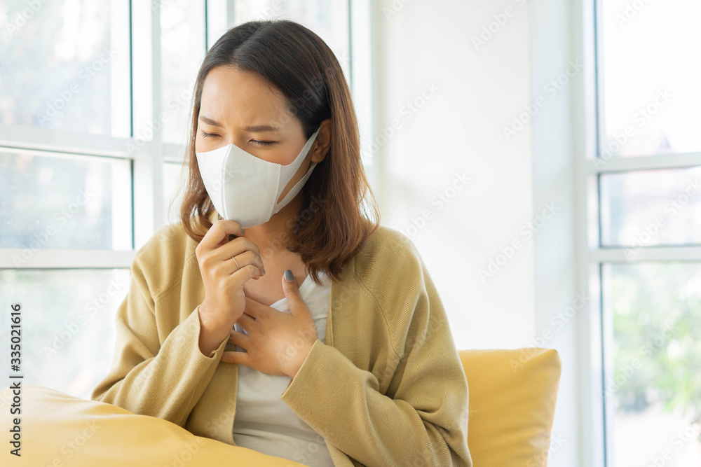 close up asian woman wear face mask coughing and touching on chest to check lung while breathing in quarantine area for coronavirus preventive concept close up asian woman wear face mask coughing and touching on chest to check lung while breathing in quarantine area for coronavirus preventive concept