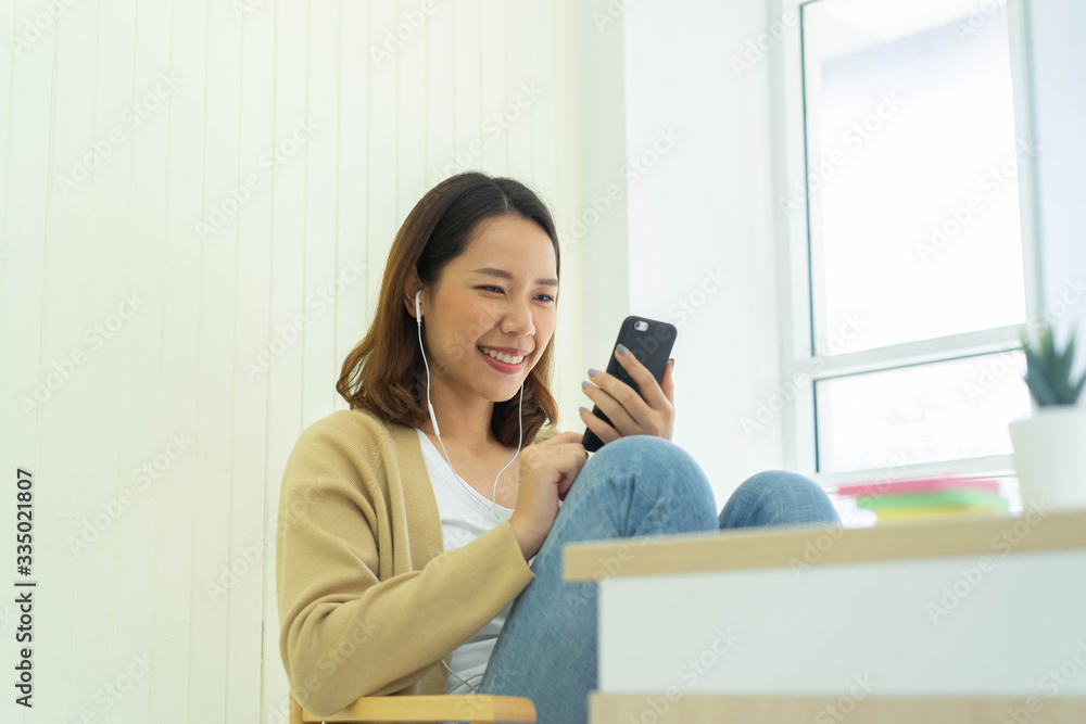 close up young asian woman holding smartphone to communicate with friends and family inside houses's living room in weekend for social distance and quarantine time concept close up young asian woman holding smartphone to communicate with friends and family inside houses's living room in weekend for social distance and quarantine time concept