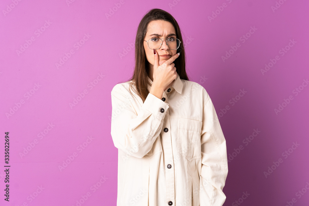 Young woman over isolated purple background having doubts Young woman over isolated purple background having doubts