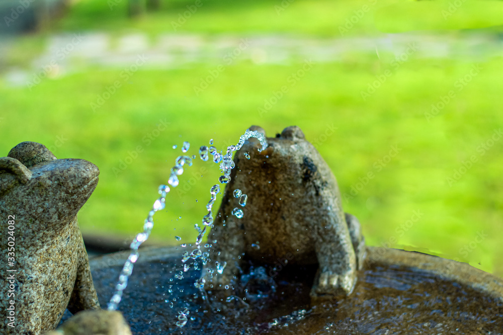 fountain of three granite frogs playing with the water