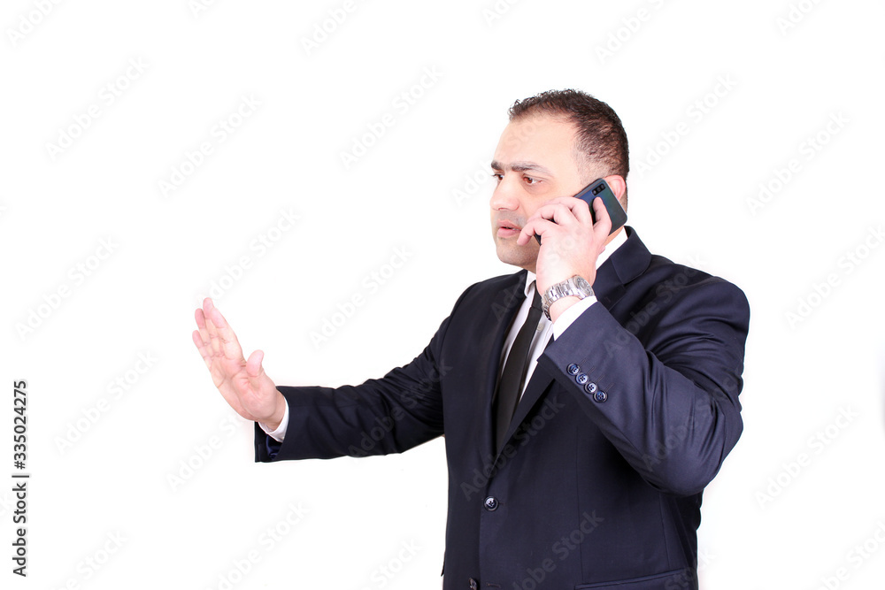 Serious businessman in a suit and tie arguing by the phone. Business concept isolated Serious businessman in a suit and tie arguing by the phone. Business concept isolated