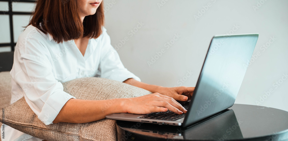 young woman working on laptop computer while sitting at the living room. work from home concept young woman working on laptop computer while sitting at the living room. work from home concept