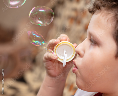 The boy blows up soap bubbles