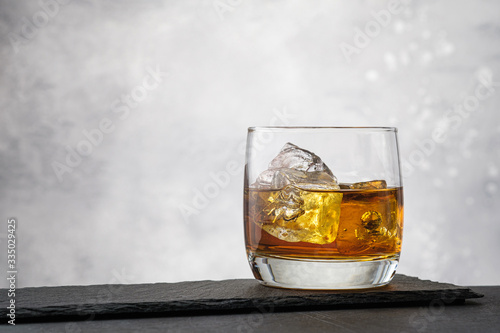 Close-up whiskey with ice cubes on gray background