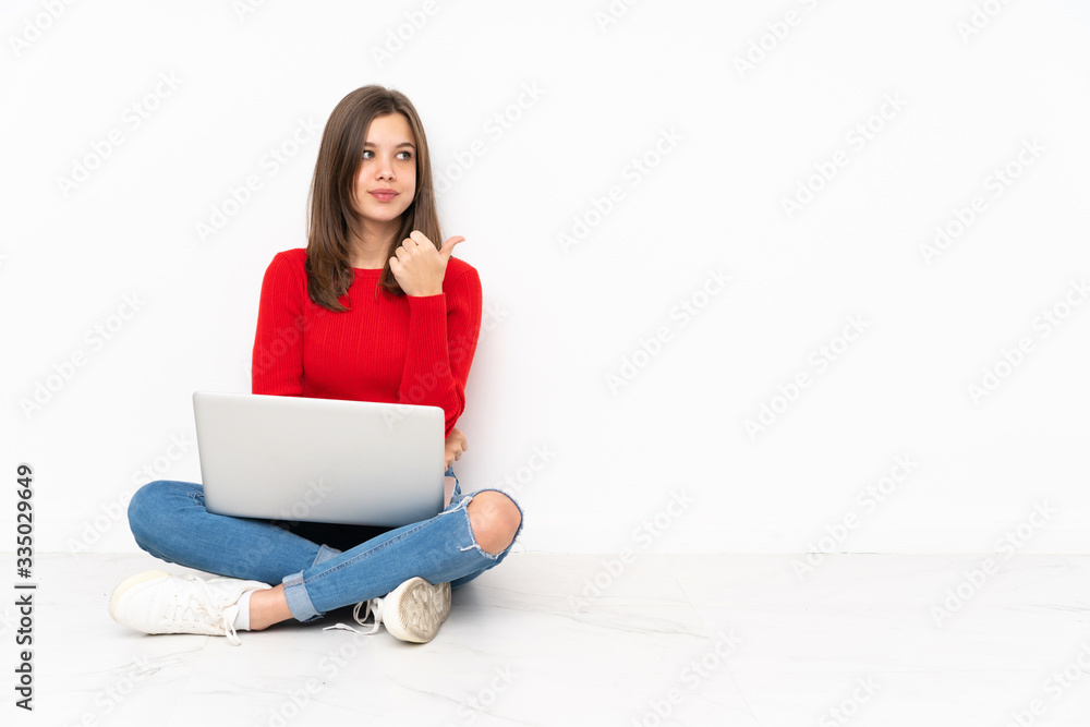 Tenaager girl working with pc isolated on white background pointing to the side to present a product Tenaager girl working with pc isolated on white background pointing to the side to present a product