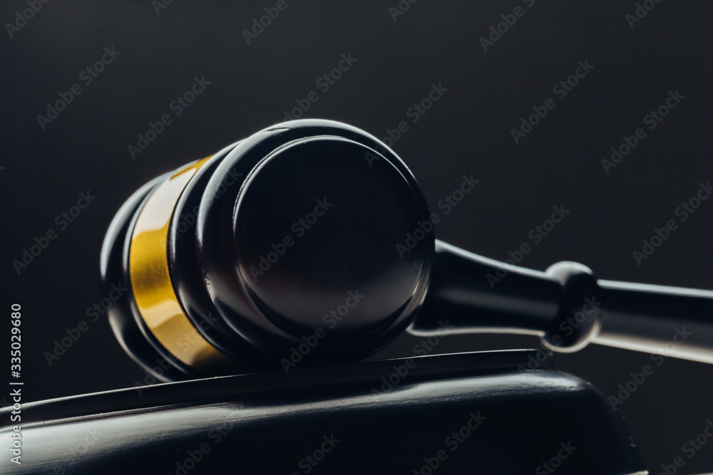 Judge's gavel with gold metal on a black table. Concept of law