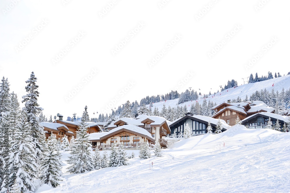 Ski resort with beautiful wooden chalets next to the slope 