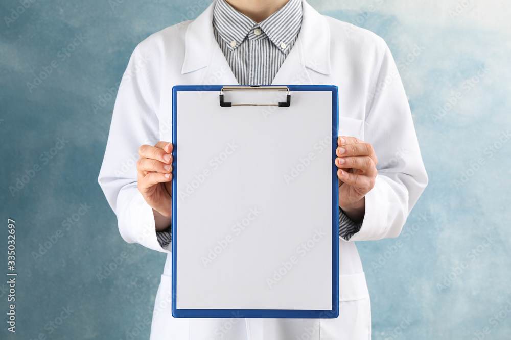 Doctor holds empty tablet on blue background, space for text Doctor holds empty tablet on blue background, space for text
