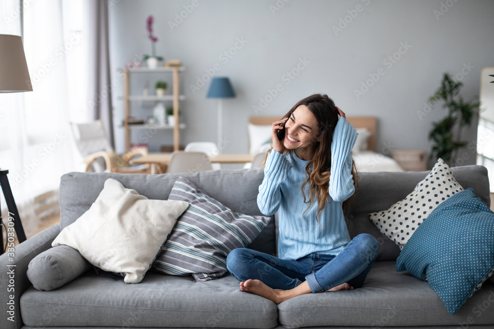 Happy woman with smartphone in casual wear on the couch. Happy woman with smartphone in casual wear on the couch.
