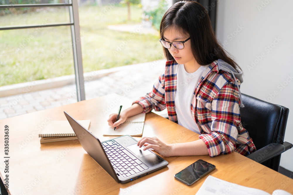 Young Asian female student working and studying from home Young Asian female student working and studying from home