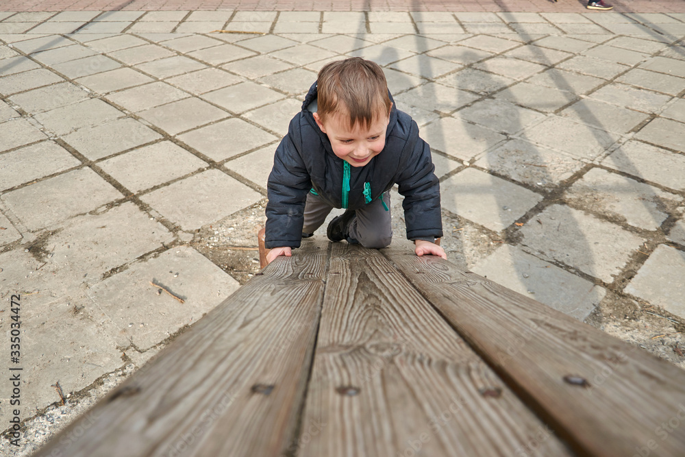 little boy is climbing on a wooden board. little boy is climbing on a wooden board.
