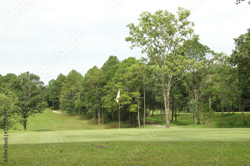 The evening golf course has sunlight shining down at golf course in Thailand