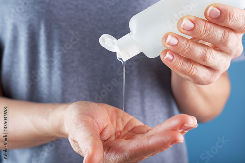 Close-up of a girl holding a Disinfectant gel in her hands. Antiseptic treatment of hands from bacteria Sanitizer.