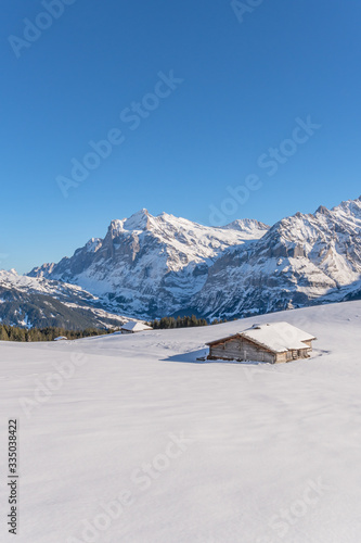 Verschneite Winterlandschaft mit einsamer Berghütte in den Schweizer Bergen