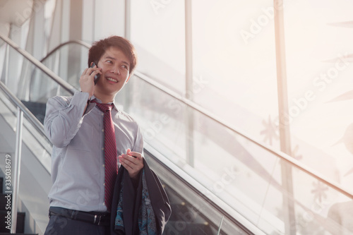 Handsome smiling confident businessman talking something on smart phone.