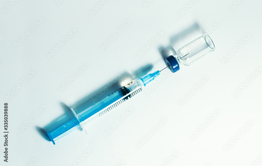 Glass medicine bottle with vaccine injection fluid with aluminium cap and syringe for vaccination, Coronavirus Covid-19 concept. Glass medicine bottle with vaccine injection fluid with aluminium cap and syringe for vaccination, Coronavirus Covid-19 concept.