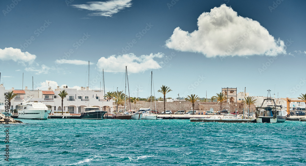 Spain, Formentera, 29 April 2018: The harbor of famous Formentera, a lighthouse, azure water, boats, sunny weather, without people