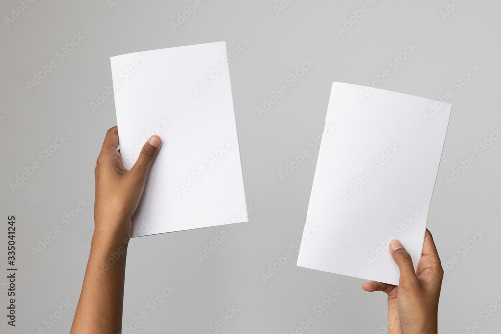 © TheCreativeBrigade - Woman of color holding and A5 or half letter size blank mockup.