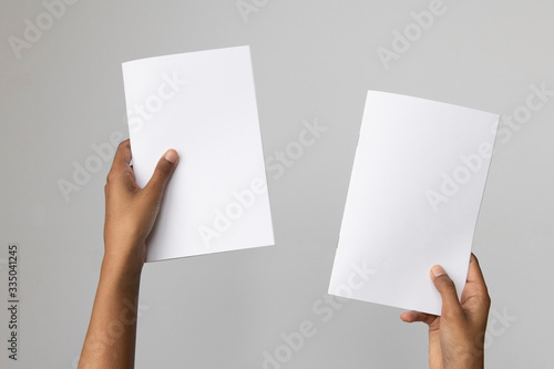 Woman of color holding and A5 or half letter size blank mockup.