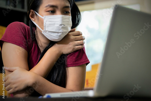Asian woman work at home for protect covid-19 or coronavirus. Women working laptop computer is sick wearing mask.