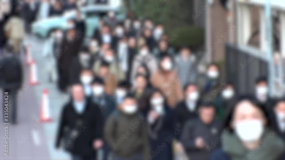 TOKYO, JAPAN -MARCH 2020 : Crowd of people walking down the street in morning rush hour. Commuters going to work. People wearing mask to protect from Coronavirus(COVID-19) or cold. Blurred slow motion TOKYO, JAPAN -MARCH 2020 : Crowd of people walking down the street in morning rush hour. Commuters going to work. People wearing mask to protect from Coronavirus(COVID-19) or cold. Blurred slow motion