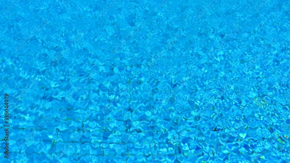 Pure Blue Water In The Swimming Pool. Ripple And Waves In Clear Turquoise Water. Glare And Reflection In Pellucid Floating Water. Water Pool Aqua Surface Background. Pure Blue Water In The Swimming Pool. Ripple And Waves In Clear Turquoise Water. Glare And Reflection In Pellucid Floating Water. Water Pool Aqua Surface Background.