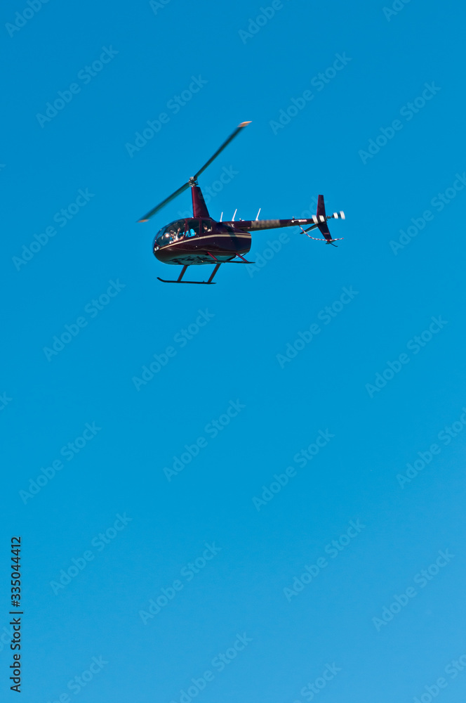 Front, bottom view of a comercial helicopter, , flying of tropical beach on gulf of mexico on a sunny, winter day Front, bottom view of a comercial helicopter, , flying of tropical beach on gulf of mexico on a sunny, winter day