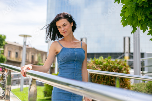 horizontal portrait of a young european woman against the backdrop of a beautiful modern building