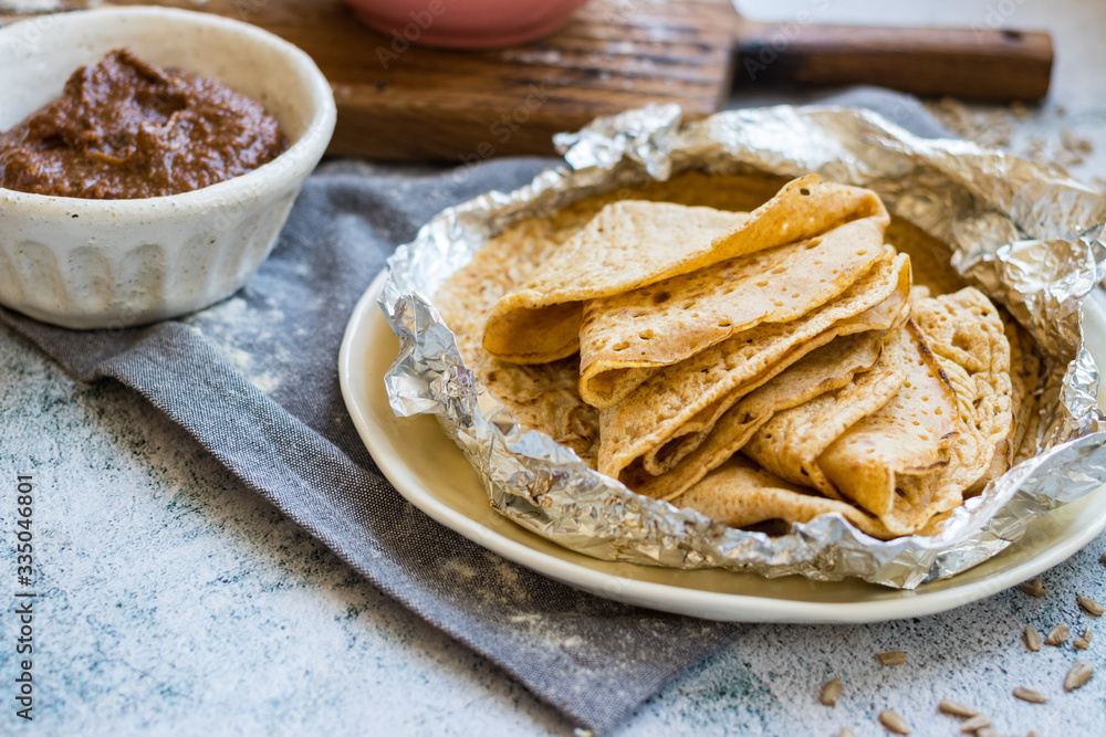 Baked crispy tasty crepes or thin pancakes and crepes dough. Ingredients on table. Vegan dessert. Homemade chocolate paste spread. Baked crispy tasty crepes or thin pancakes and crepes dough. Ingredients on table. Vegan dessert. Homemade chocolate paste spread.