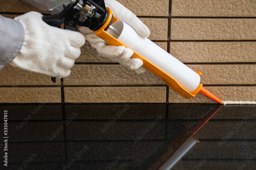 Technician man hand holding glue gun with silicone adhesive or manual