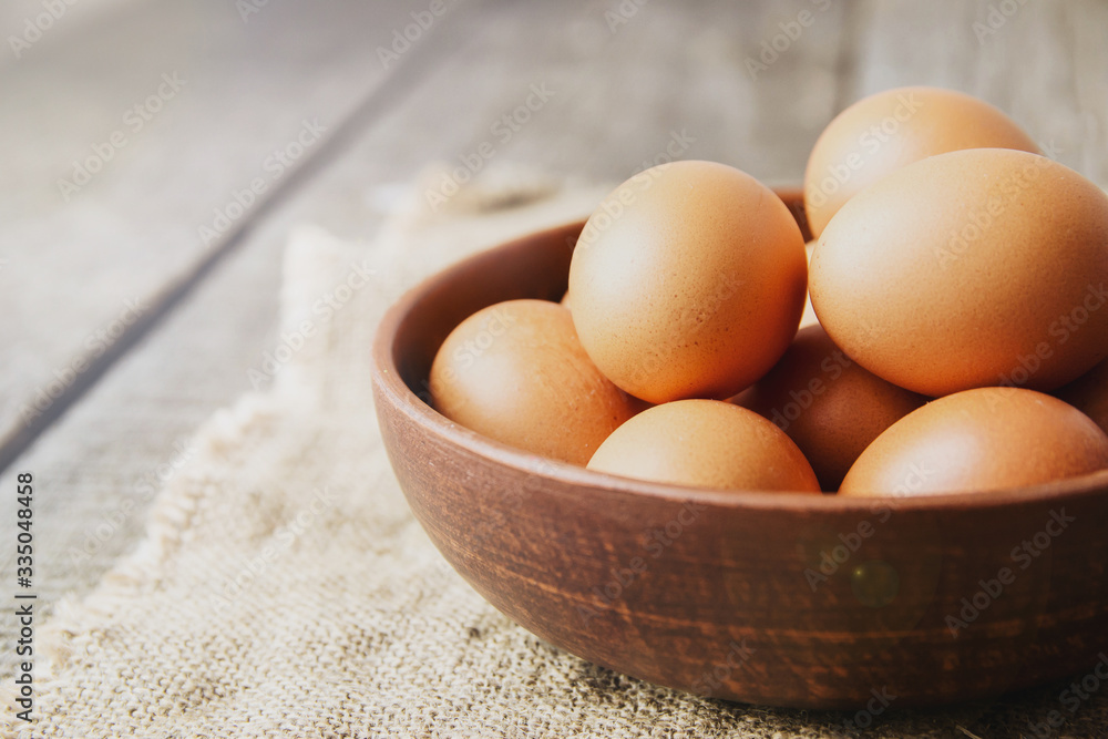 eggs in a clay plate on burlap and on an old wooden background. copy space. eggs in a clay plate on burlap and on an old wooden background. copy space.