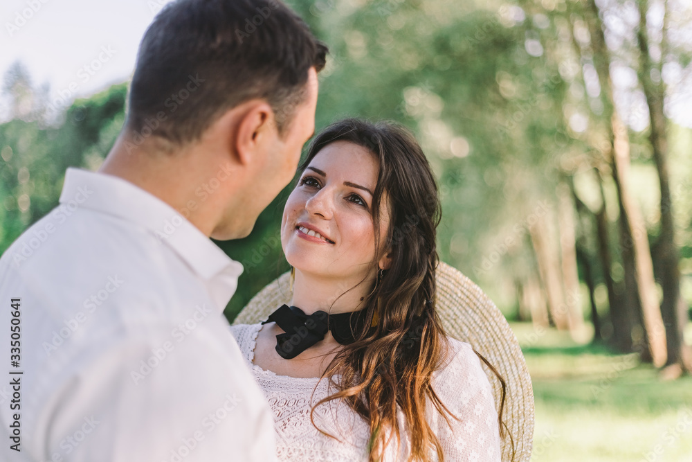 Close up beautiful wedding couple. Groom kissing his charming bride in beautiful wedding dress. Park outdoors