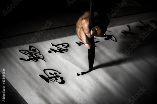 Hand of a chinese calligrapher writing beautiful characters with a brush in Qufu, China photo