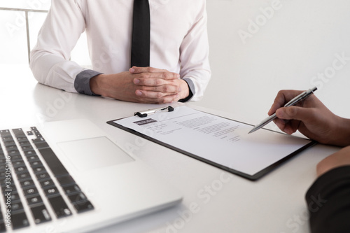 Fototapeta Naklejka Na Ścianę i Meble -  Interview employee reading a resume with the job seeker sitting in front