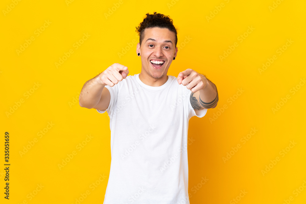 Caucasian man over isolated background surprised and pointing front Caucasian man over isolated background surprised and pointing front