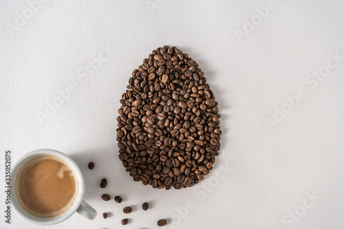 Canvas Print Creative flat lay composition with easter egg shape made of coffee roasted beans