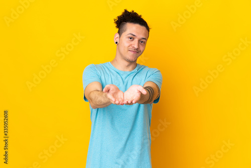 Caucasian man over isolated background holding copyspace imaginary on the palm to insert an ad