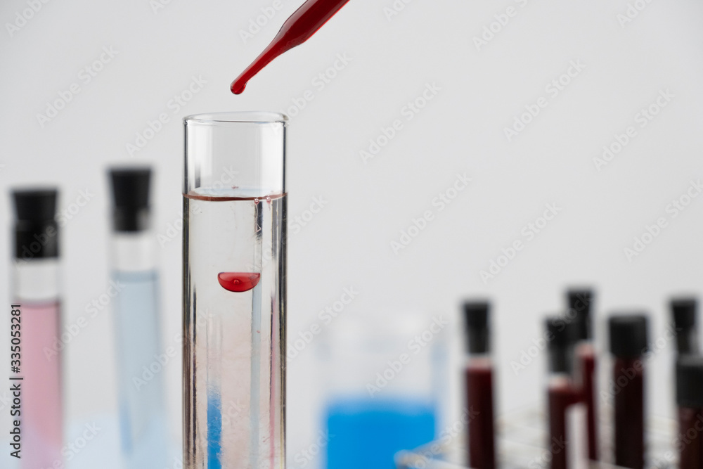 Clear science liquid in test tube with blood sample from pipette ...