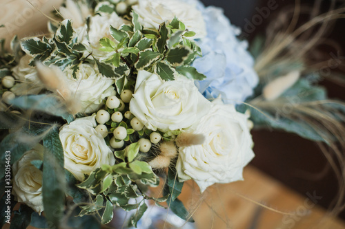 Wedding bouquet for the bride. Flowers in blue, white colors. Ingredients: hypericum, rose cream, hydrangea (sort Peppermint blue), phlebodium, pittosporum (sort Nigra) and other ornamental foliage.