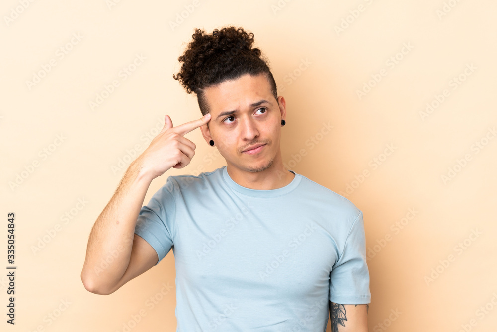 Caucasian man over isolated background making the gesture of madness putting finger on the head