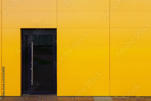 The bright facade of the building is sheathed in aluminum with one glass door