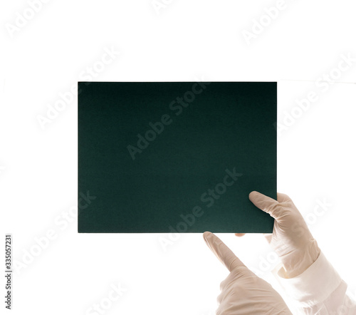 Doctor's hands in latex medical gloves holding a cardboard tablet with copy space