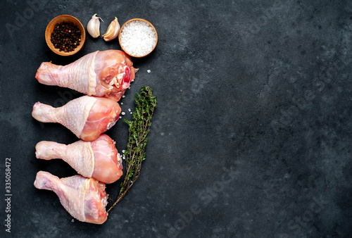 raw chicken legs with spices on a knife with copy space for your text