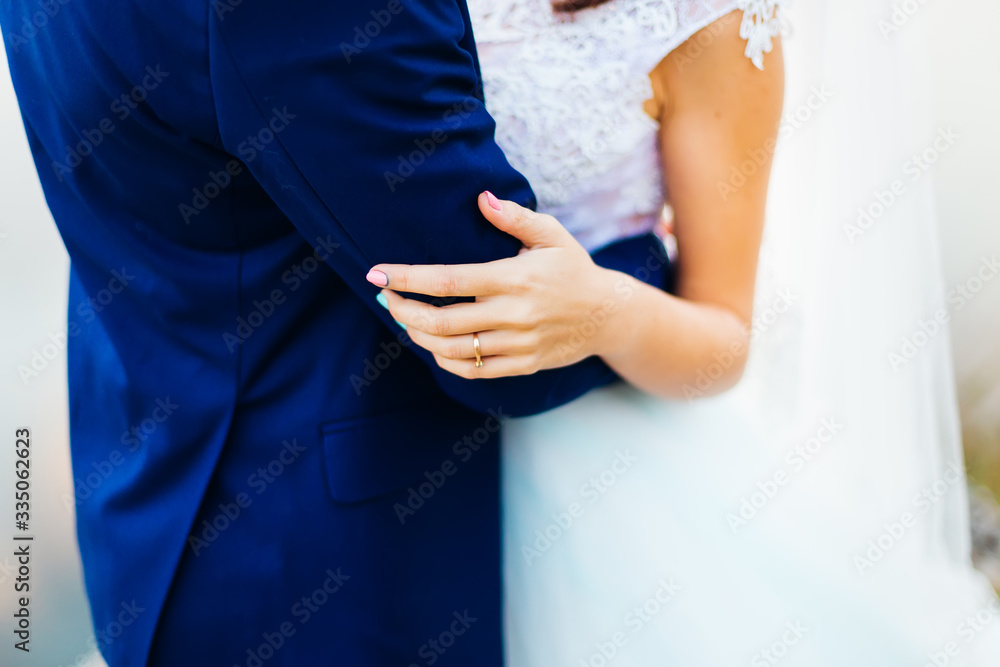 Obraz premium Close-up of hugging newlyweds. on the fingers of the bride a gol